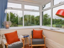 A conservatory with chairs and a table at 28 Rock Villas Carnforth