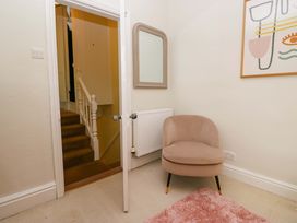 A hallway with a chair and stairs at 28 Rock Villas Carnforth