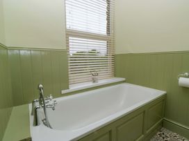 A bathroom with a bathtub and window at 28 Rock Villas in Carnforth