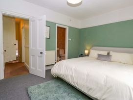 A bedroom with a bed and doors leading to a bathroom at 28 Rock Villas Carnforth