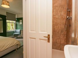 A bathroom with a shower and a doorway to a bedroom at 28 Rock Villas in Carnforth