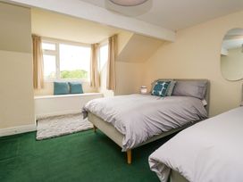 A bedroom with two beds and a window seat at 28 Rock Villas in Carnforth