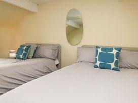 A bedroom with two beds and a mirror at 28 Rock Villas in Carnforth