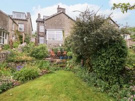 A garden with a house, chairs, and table at 28 Rock Villas in Carnforth