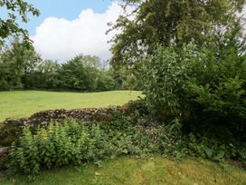 A garden with grass and a stone wall at 28 Rock Villas in Carnforth