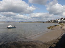 A beach with a boat in the water at 28 Rock Villas in Carnforth