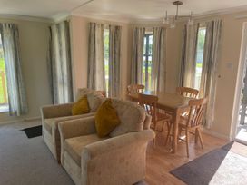 A dining room with a table and chairs at Kastel in Tregolds near St Merryn