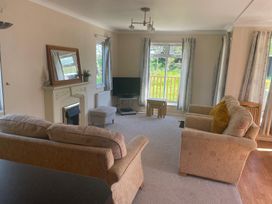 A living room with a sofa and television at Kastel Tregolds near St Merryn