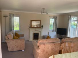 A living room with a sofa and television at Kastel in Tregolds near St Merryn