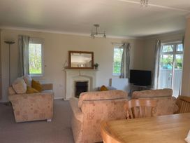 A living room with a television and seating area at Kastel in Tregolds near St Merryn