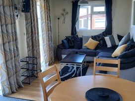 A living room with a sofa and coffee table at Gwanda in Tregolds near St Merryn