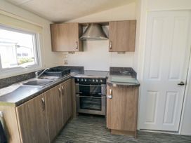 A kitchen with a double sink stove oven wall cabinets and a door at 13 Gosling in Cayton Bay