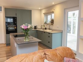 A kitchen featuring a sink, oven, and flowers on the counter at Little Willesleigh in Goodleigh near Barnstaple