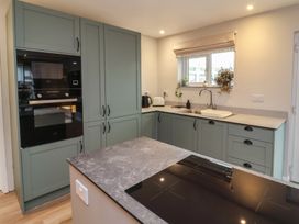 A kitchen with cabinets, appliances and a sink at Little Willesleigh in Goodleigh near Barnstaple