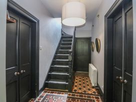 A hallway with a staircase and light fixture at Gweryl Lodge in Conwy