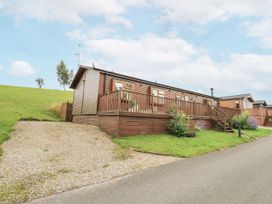 A lodge with decking and gravel driveway at Butterfly Lodge Tunstall near Catterick, North Yorkshire