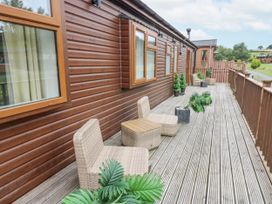A deck area with chairs and plants at Butterfly Lodge Tunstall near Catterick, North Yorkshire