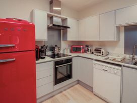 A kitchen with appliances including a red fridge and coffee machine at Full Deck in Dartmouth