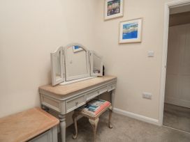A vanity table with a mirror in a bedroom at Full Deck Dartmouth