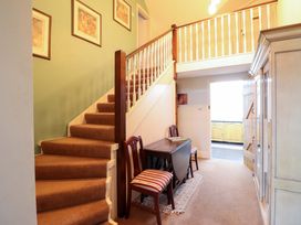 A hallway with a staircase and table at Bryn Y Garreg - The Wireless Free Farm (No Tech!) Y Trallwng