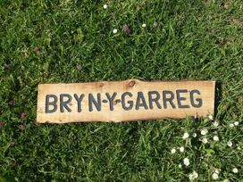 A wooden sign on grass reading BRYN Y GARREG outdoor area at Bryn Y Garreg - The Wireless Free Farm (No Tech!) Llangadfan near Llanwddyn