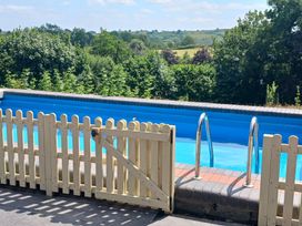 An outdoor swimming pool with a fence and ladder at Bryn Y Garreg Cottage - The Wireless Free Farm Llangadfan near Llanwddyn