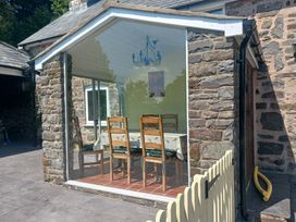 A conservatory with a table and chairs at Bryn Y Garreg Cottage - The Wireless Free Farm, Llangadfan near Llanwddyn