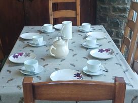 A dining room table set with cups and plates at Bryn Y Garreg Cottage - The Wireless Free Farm Llangadfan near Llanwddyn