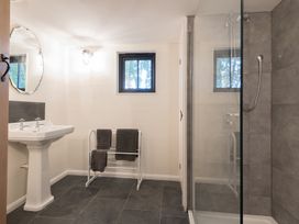 A bathroom with a pedestal sink a towel rack with towels a window and a glass shower enclosure at Walden Lodge Tresillian Wood near Llantwit Major