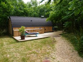 A cabin with a deck and chair in an outdoor area at Hobhole in Keal Cotes near East Kirkby