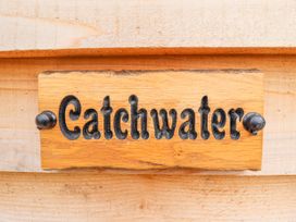 A wooden sign with the word Catchwater attached to a wooden surface
