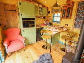 A kitchen with green cabinets yellow walls wooden floor and chairs at Catchwater Keal Cotes near East Kirkby
