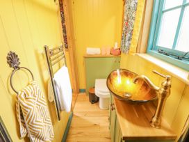 A bathroom with a glass vessel sink a toilet towels and yellow walls at Catchwater in Keal Cotes near East Kirkby