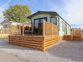 A mobile home with wooden deck and stairs on a gravel lot at Ashcroft in Warton Lancashire