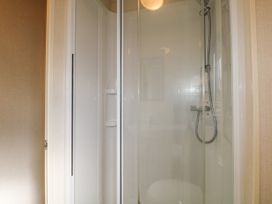A shower with glass doors and a handheld showerhead inside a bathroom at 610 Caravan in Bognor Regis
