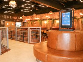 An interior seating area with brown leather circular bench and tables with chairs in a restaurant