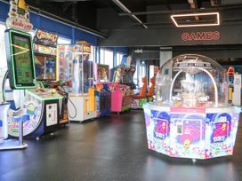 An arcade room with various arcade game machines including a doodle jump game and a ticket dome game at 610 Caravan in Bognor Regis