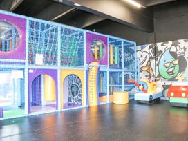An indoor children's play area with climbing nets, tunnels, and a ride-on airplane at 610 Caravan in Bognor Regis