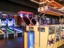 An indoor arcade with skee ball machines basketball shooting games and a high striker game at 610 Caravan in Bognor Regis