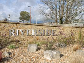 A stone wall with the word Riverside on it surrounded by gravel, rocks, and plants at 610 Caravan in Bognor Regis