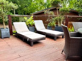 An outdoor area with sun loungers and a table at Tree House, Partial Lake Views, Windermere