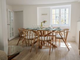 A dining room with a glass table surrounded by wooden chairs and set with bowls and wine glasses at 47 Church Street Lyme Regis