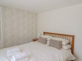 A bedroom with a double bed with folded towels on the bed and a bedside table with lamp at 47 Church Street in Lyme Regis