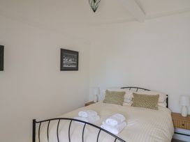 A bedroom with a double bed with folded towels on it and bedside tables with lamps at 47 Church Street in Lyme Regis