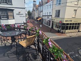 A terrace with table and chair overlooking a street at Harbour Retreat in Weymouth