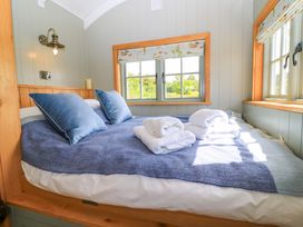 A bedroom with a bed and pillows at Goose Whistle Hut in Foxham