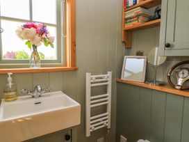 A bathroom with a sink and window at Goose Whistle Hut in Foxham
