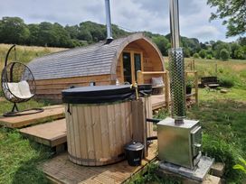 An outdoor area with a wooden cabin and a hot tub at Holbein in Matlock