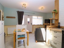 A kitchen with a dining table and a refrigerator at Rainbow's End in Swanton Morley