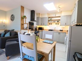 A kitchen with a sofa and dining table at Rainbow's End in Swanton Morley